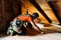 a man working on a wooden floor in an attic